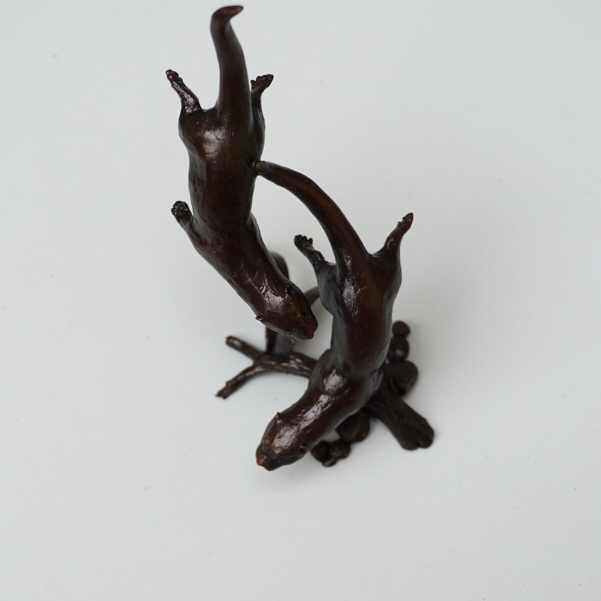 solid bronze sculpture of two otters swimming