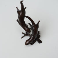 solid bronze sculpture of two otters swimming