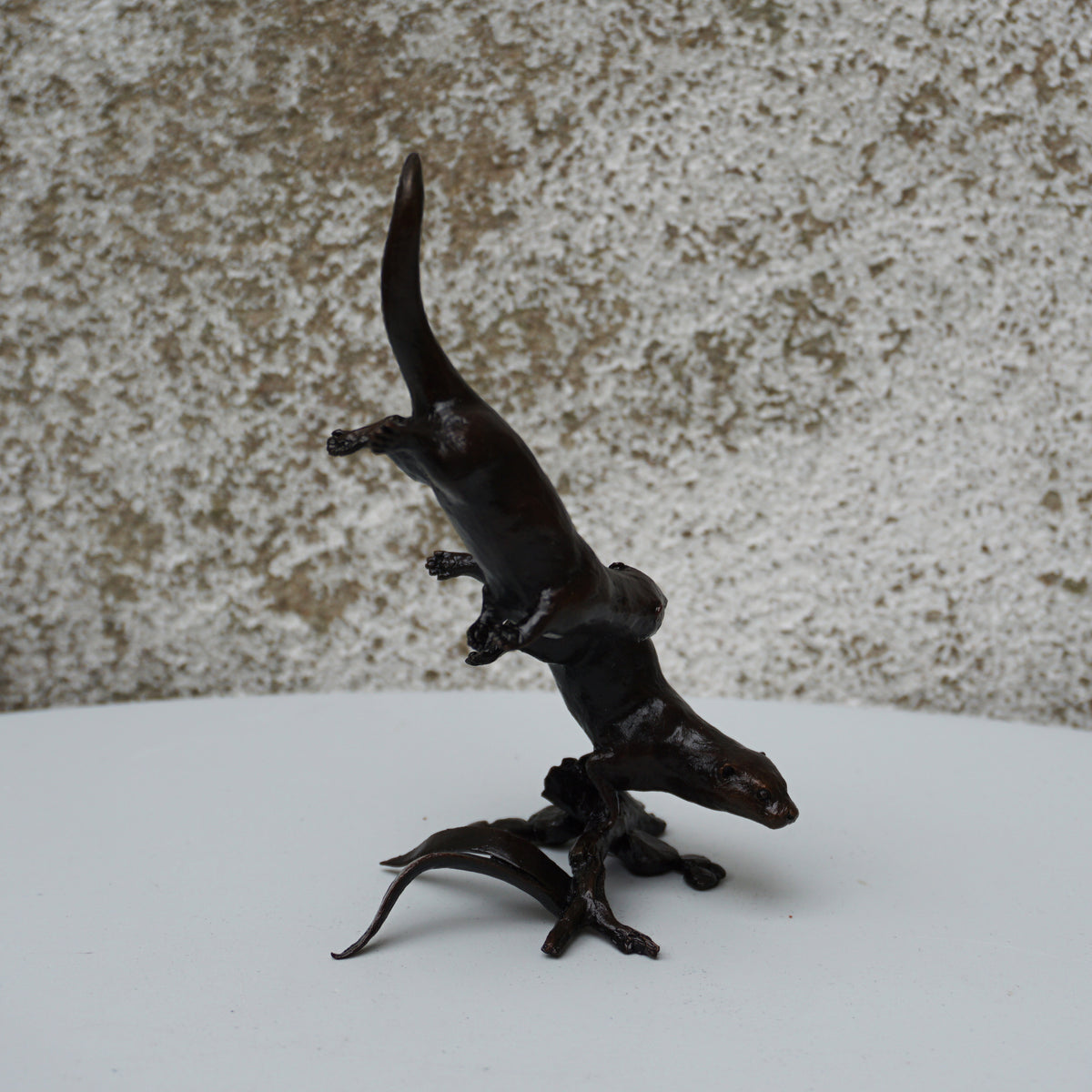 solid bronze sculpture of two otters swimming