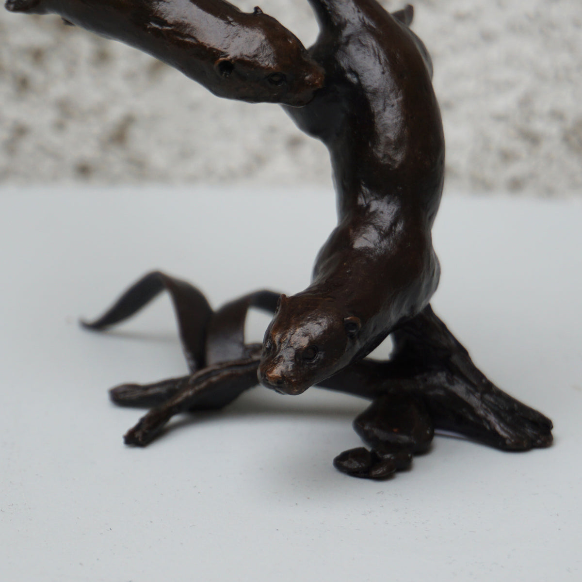 solid bronze sculpture of two otters swimming