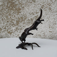 solid bronze sculpture of two otters swimming